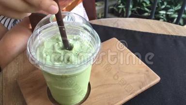 木桌上的玻璃杯里有筒子的绿茶味道。